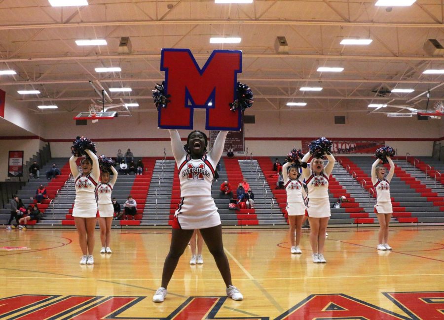 Senior Paola Kangni-Soupke holds up an M as she performs the teams cheer at halftime. Photo by Carly Barkus.