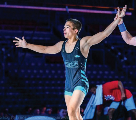 Junior Joel Adams celebrates his gold medal win, taking home the title in both freestyle and Greco-Roman.