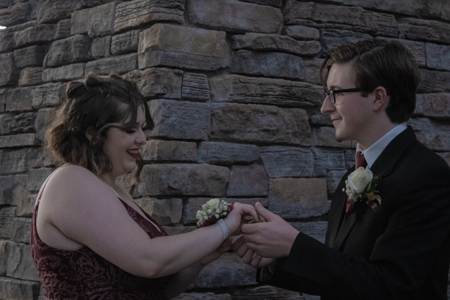 Senior Dominic Bakk puts a corsage on senior Maddie Conrads wrist. The couple took their pre-prom photos at Regency Court before heading to dinner at the Upstream.
-Photo by Jennifer Castle