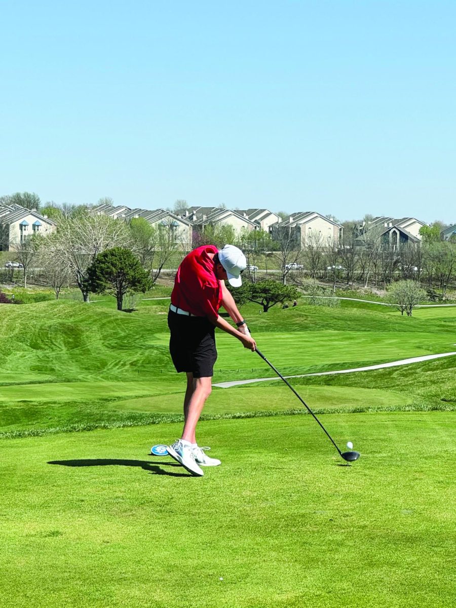 Senior Harrison Clements connects with ball on tee shot during tournament.