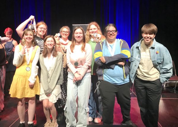 The team stands together, holding up silver medals from the All Writes Reserved festival.