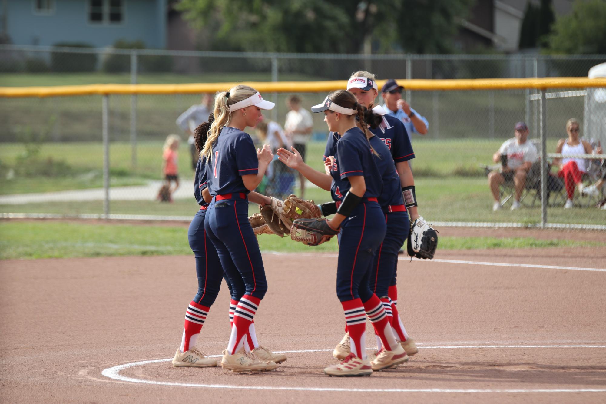 Millard South softball gives each other high fives before taking the field