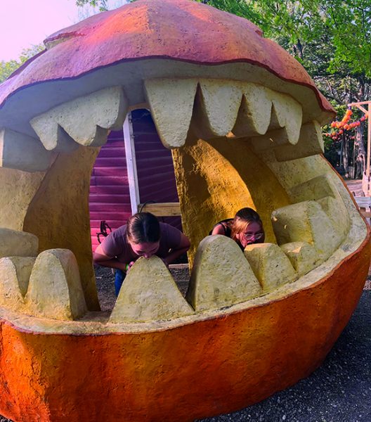 Sophomores Faith Ford and Madalyn Kreuzburg bit the giant pumpkin at Valas.