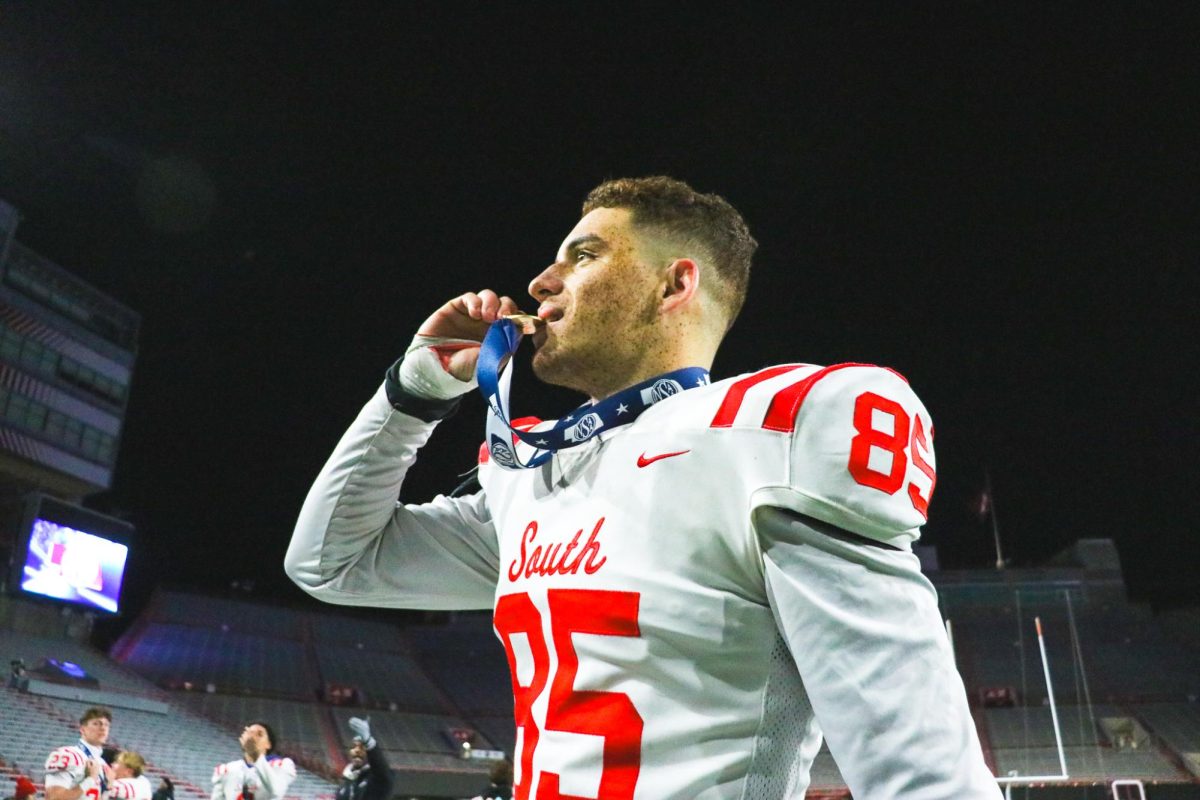 Solomon Baker bites the gold medal after winning the State championship.