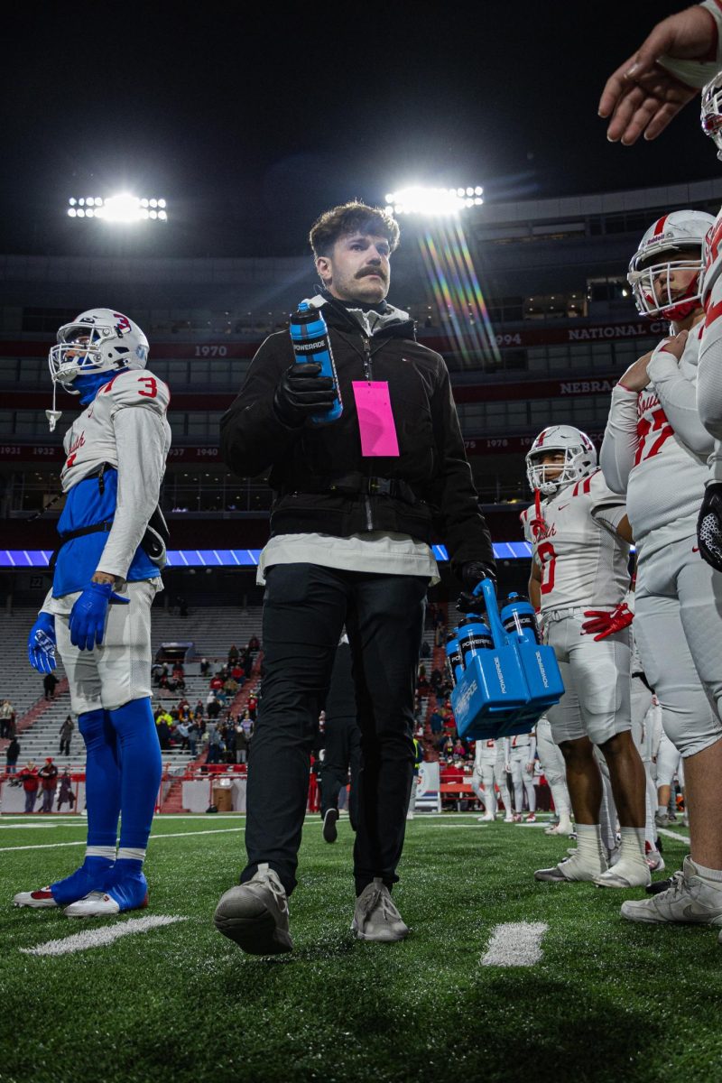 Athletic Trainer Luke Partusch delivers water to the players during pregame warm ups. 