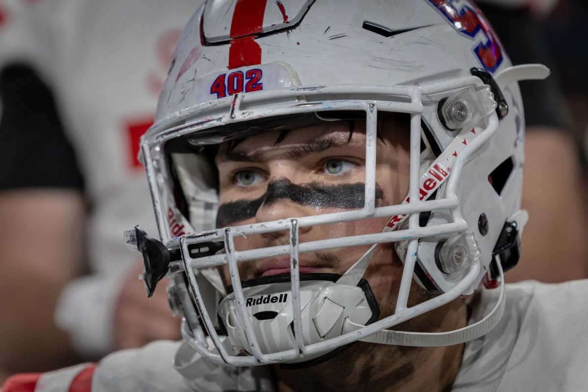 Junior Jack Ladd analyzes the game as the team huddles to watch the last play. 