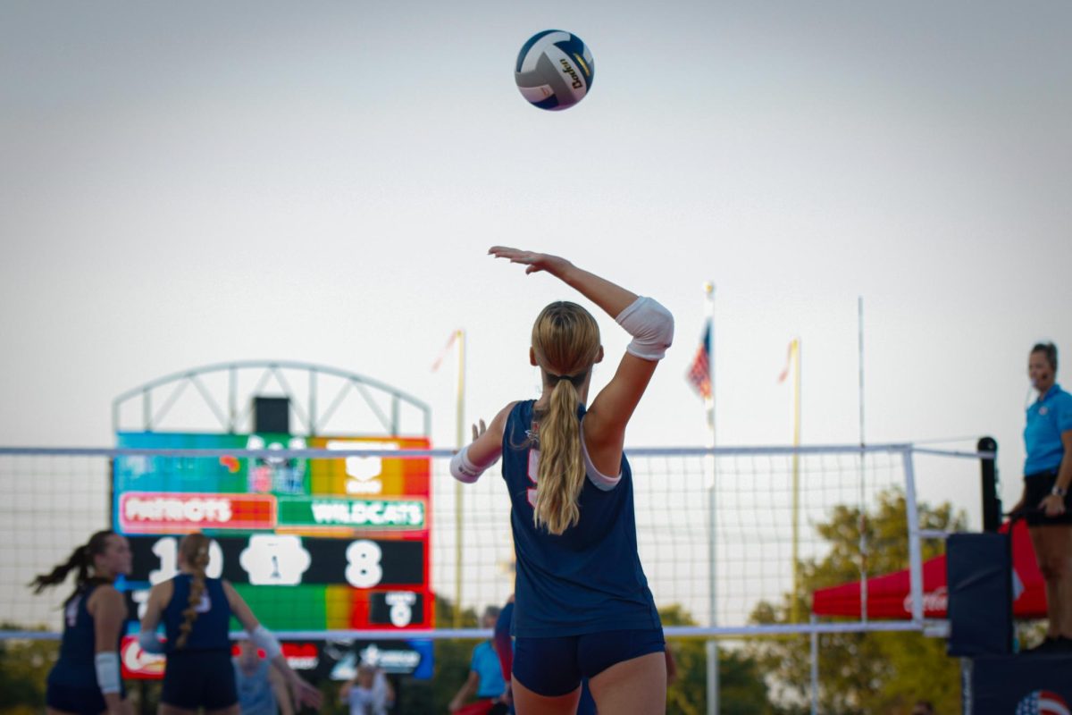 Sophomore Madi Jacobson lofts a serve into the sunset.