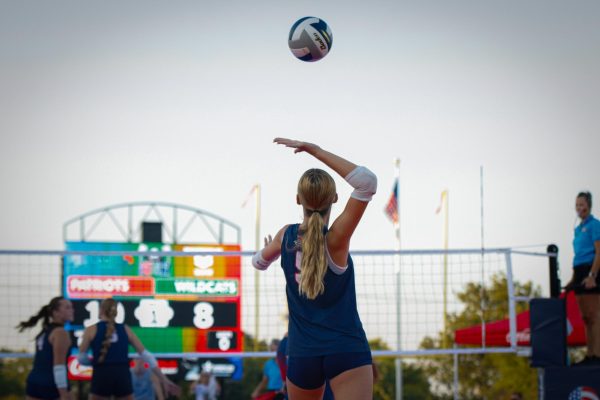 Sophomore Madi Jacobson lofts a serve into the sunset.
