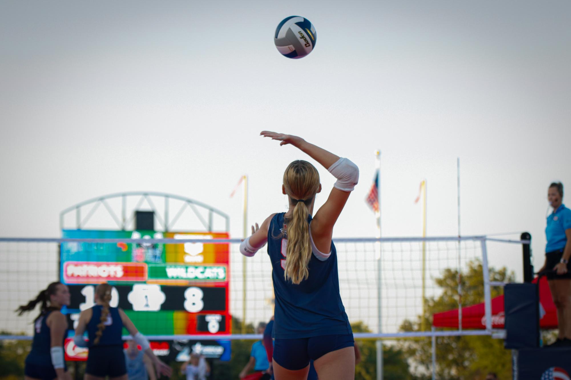 Sophomore Madi Jacobson lofts a serve into the sunset.