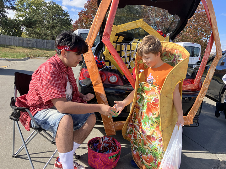 With his Spiderman themed 2002 Acura RSX, junior Romeo Arregiun sits in a camping chair and hands out candy to the kids in the West Lot. 