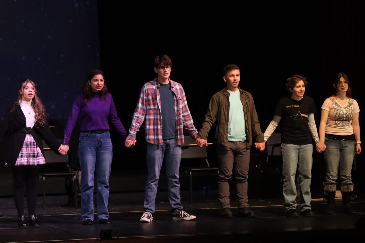 Actors hold hands as they sing the ending number of the musical.