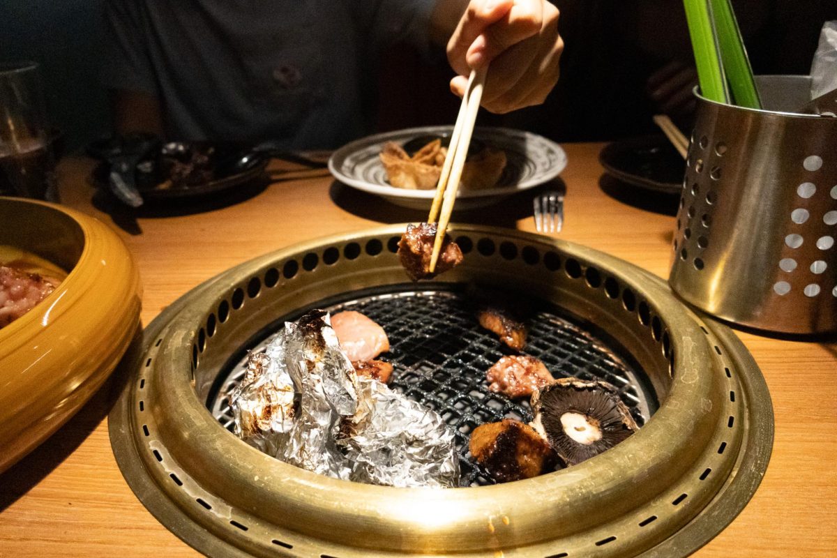 Junior Maggie Ho selected piece of pork from barbeque grill