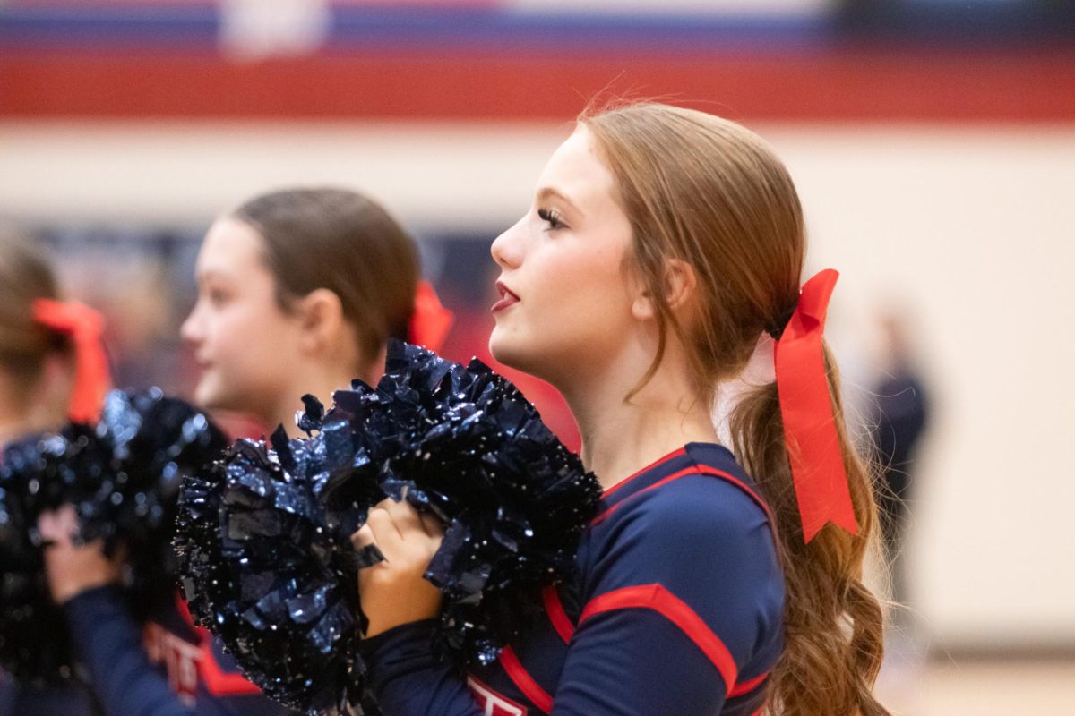Freshmen cheerleader Kinsley Crosta takes to the frontlines of the crowd, chanting the teams rehearsed cheers while showing school spirit. 