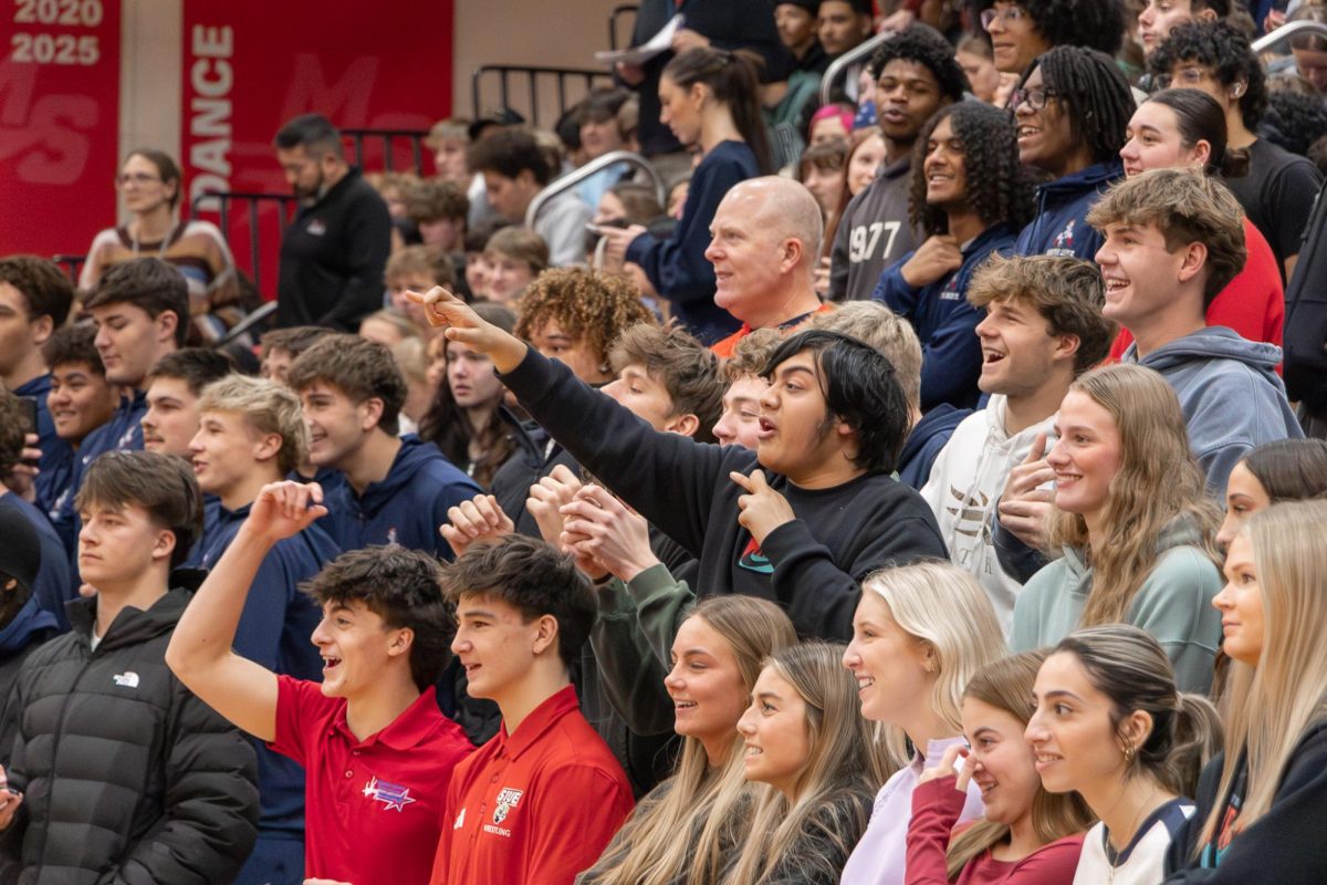 Seniors Gunner Rettele, Kiernan Meink, Takbir Chowdhury, Addy Kuhl, and Tessa Carol stand in acclaimation as peprally game takes place.