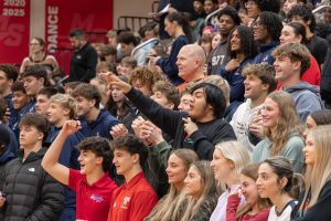 Seniors Gunner Rettele, Kiernan Meink, Takbir Chowdhury, Addy Kuhl, and Tessa Carol stand in acclaimation as peprally game takes place.