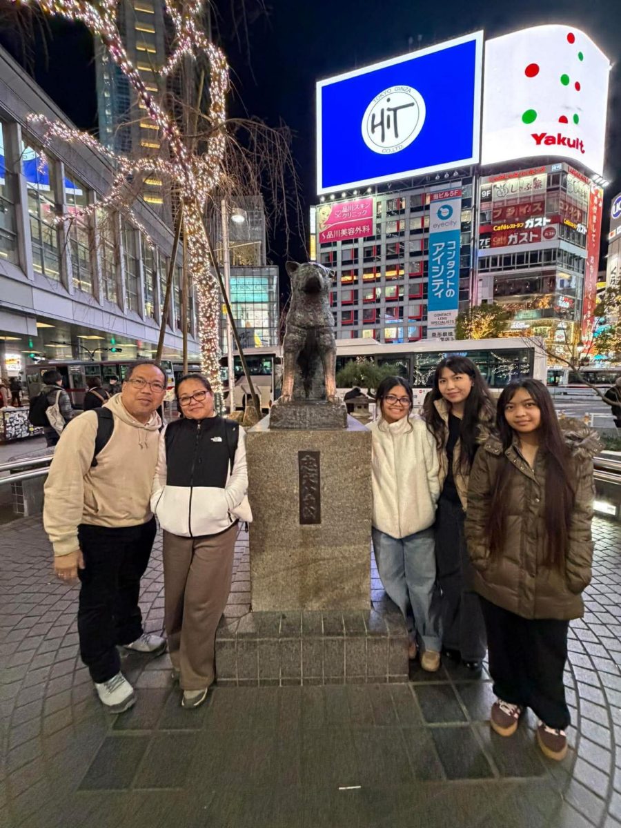 Avery and her family stand in front of the Hachiko statue in Shibuya Crossing.