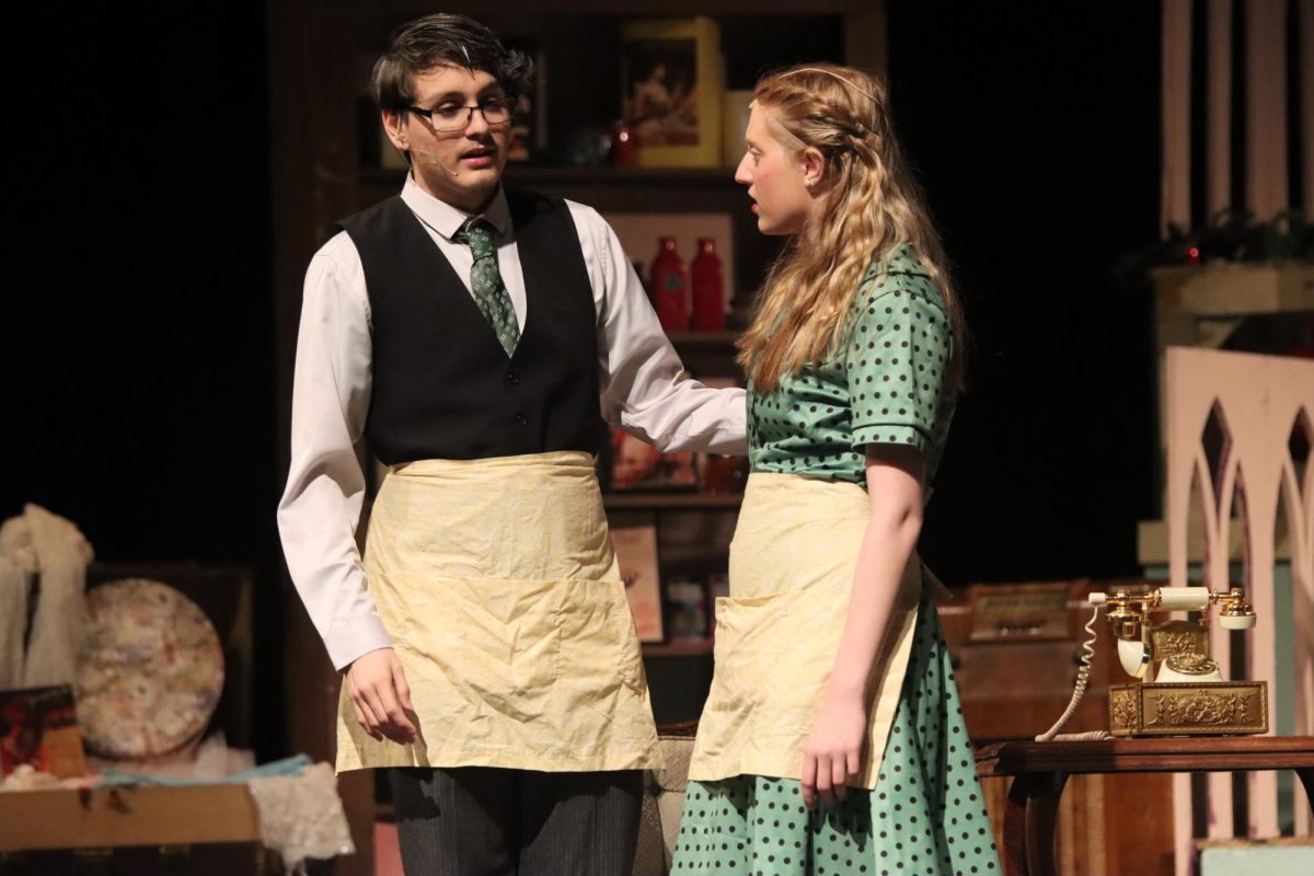 Mr. Sipos (Ethan Schmidt) talks to Amalia Balash (Hailey Linnell) about her relationship with Horvath (Alex Zezulka). 